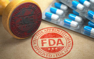 Red FDA approval stamp beside blue and white pills.