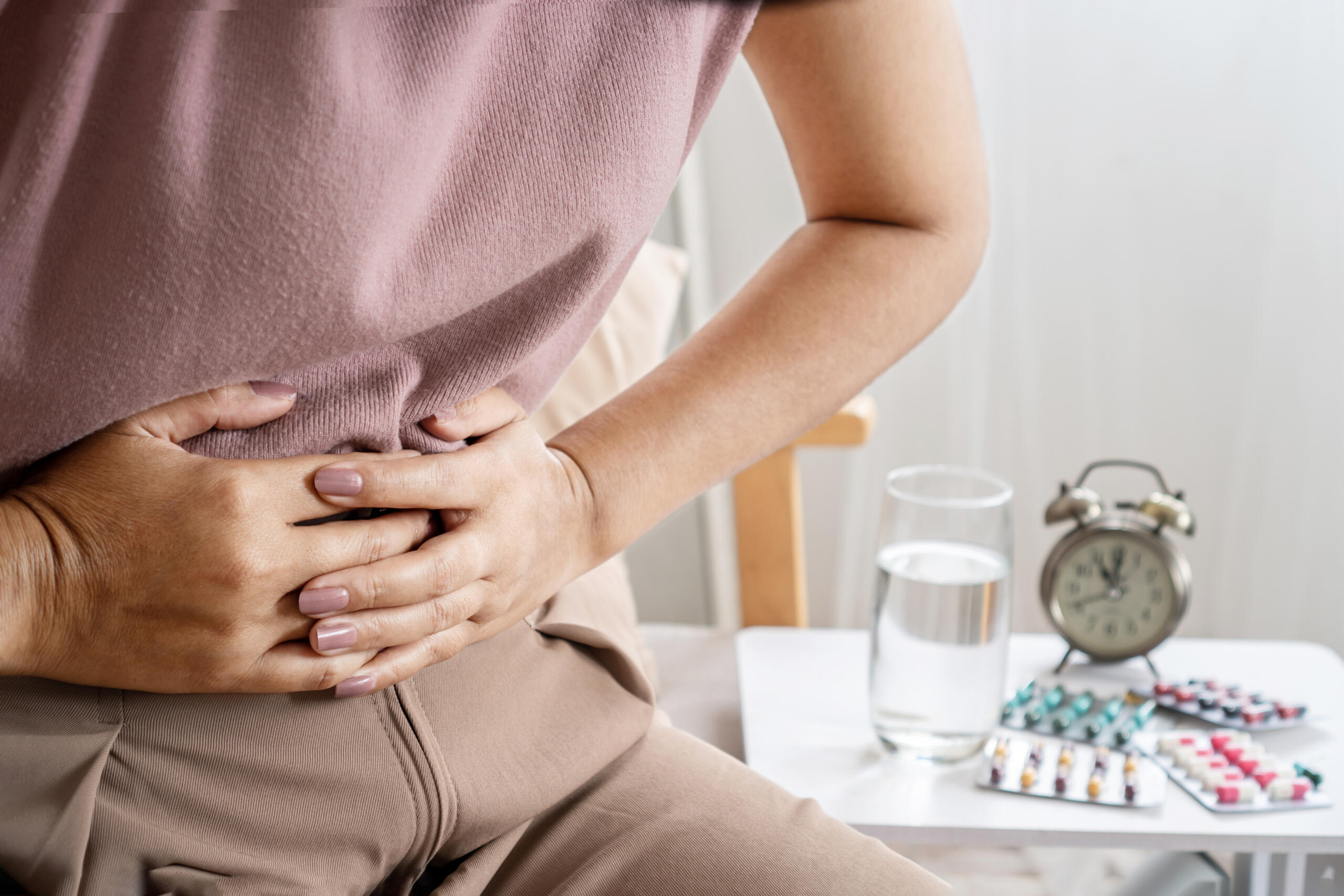 irritable bowel syndrome IBS concept with woman hand holding a stomachache having problems with the digestive system like diarrhea and constipation.