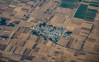 Aerial photography of rural settlement surrounded by agricultural fields.