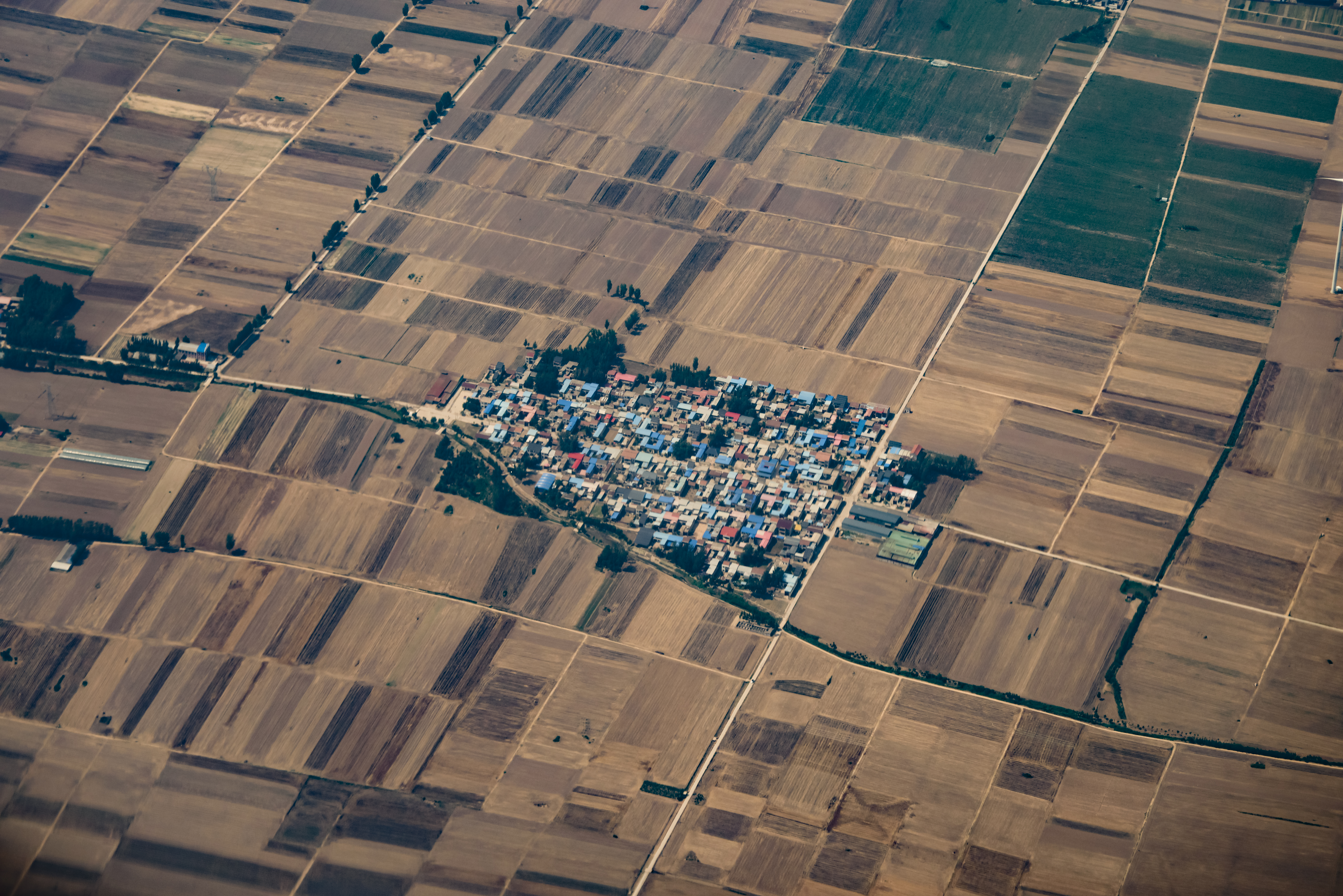 Aerial photography of rural settlement surrounded by agricultural fields.