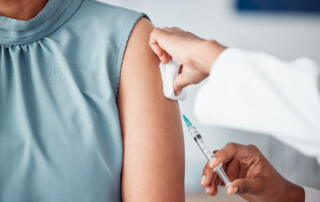 Hands, medical and doctor with patient for vaccine in a clinic for healthcare treatment for prevention. Closeup of a nurse doing a vaccination injection with a needle syringe in a medicare hospital.